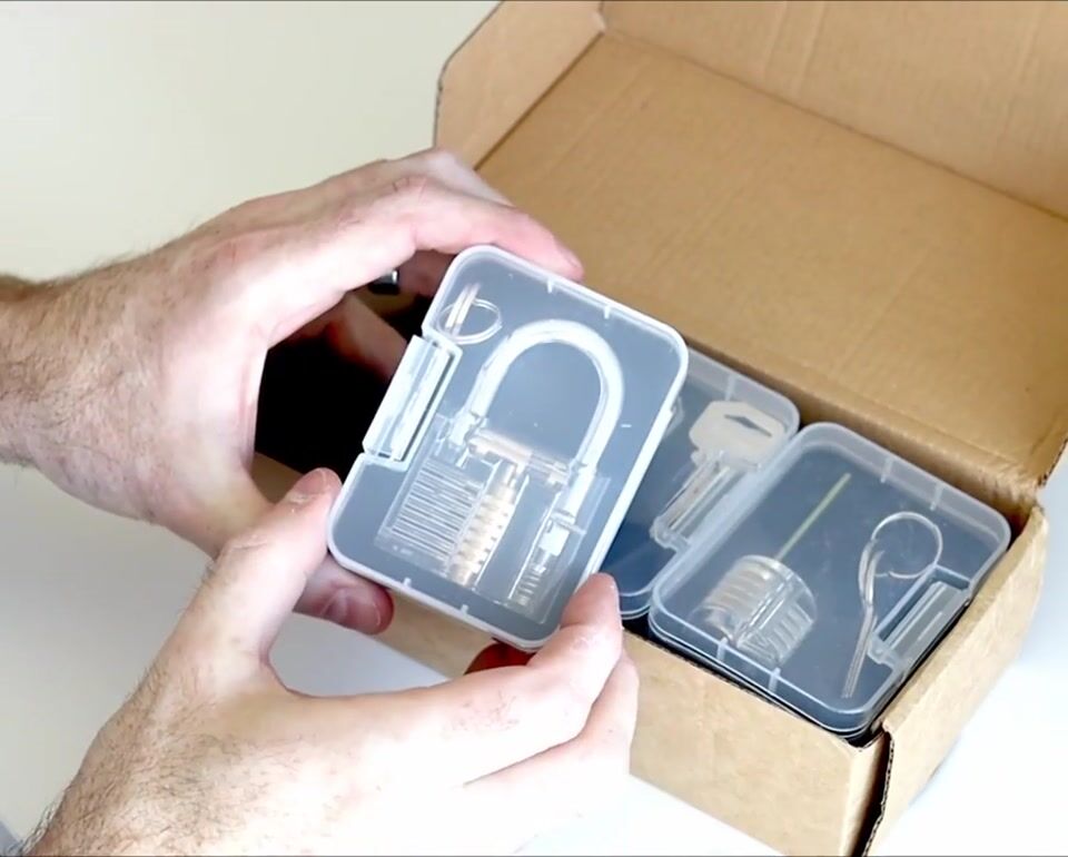 Unboxing video: a hand resting on an unopened kit box, with a play button